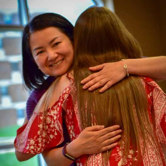 Professor hugging student after giving her an award